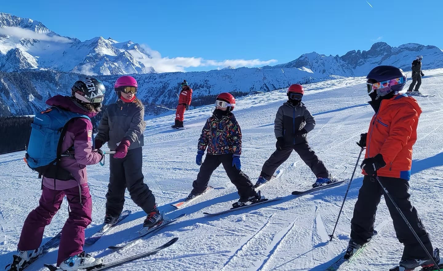 Crianças acompanhadas durante uma aula de ski nas montanhas